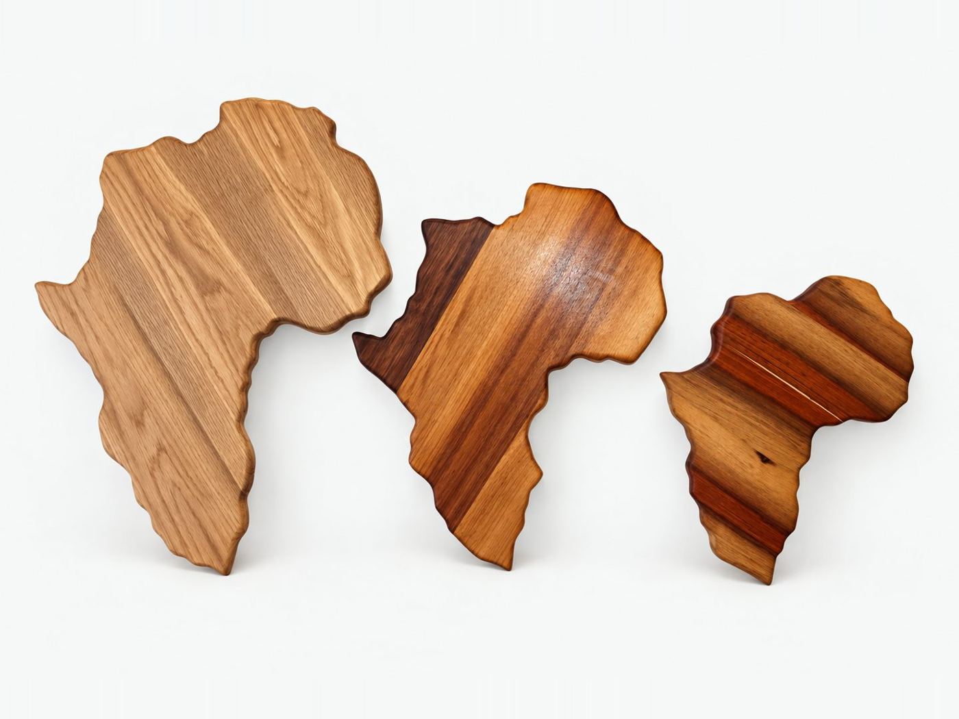 Three Africa shaped serving boards in oak, teak and mixed hardwood